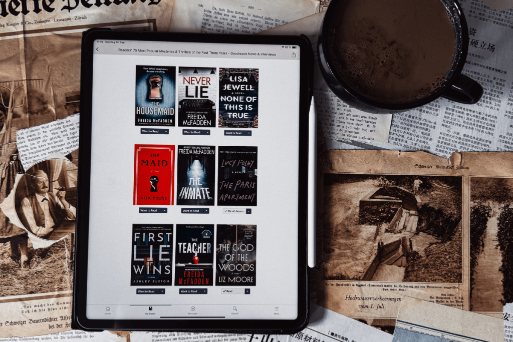 Tablet mit geöffneter Goodreads App auf der Seite einer Bücherliste, daneben eine Tasse Kaffee